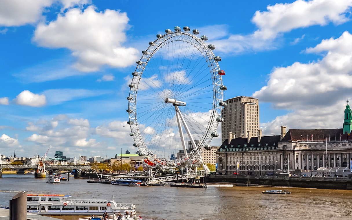 London Eye on the Thames River with cityscape background.