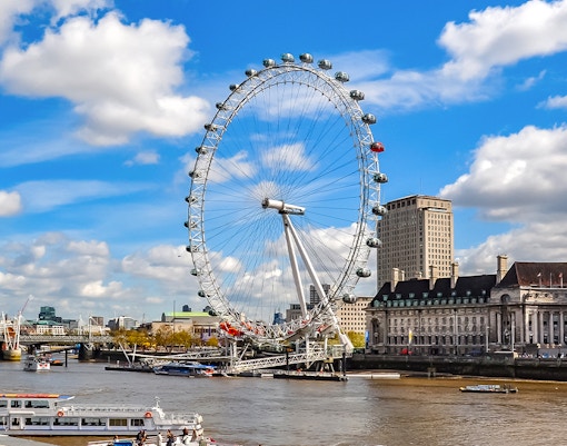 London Eye on the Thames River with cityscape background.