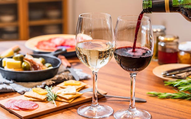 Red and white wine with charcuterie and cheese on a Paris gourmet food tour.