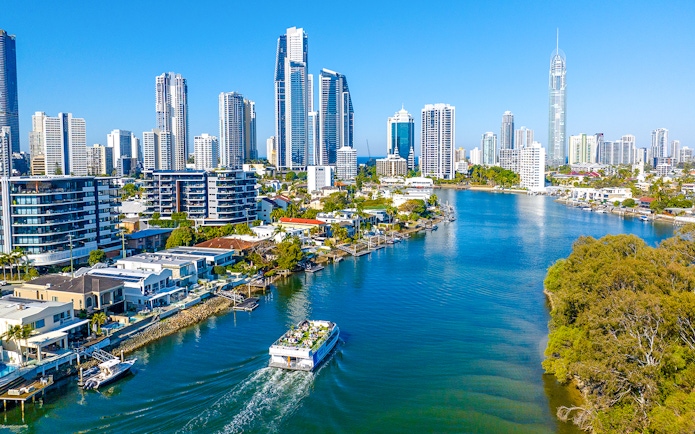 Drone view of vessel on Gold Coast waterway with Surfers Paradise skyline.