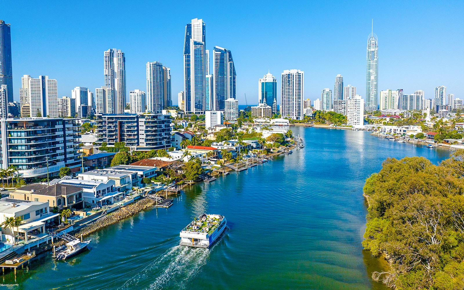 Drone view of vessel on Gold Coast waterway with Surfers Paradise skyline.