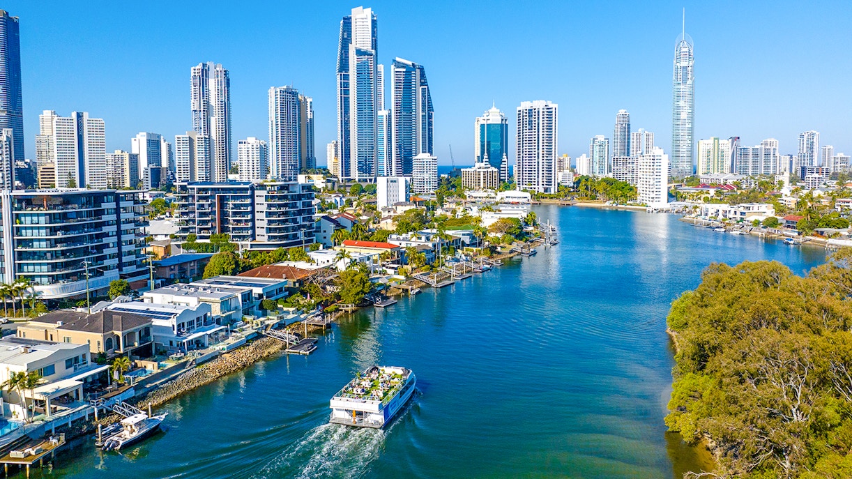 Drone view of vessel on Gold Coast waterway with Surfers Paradise skyline.