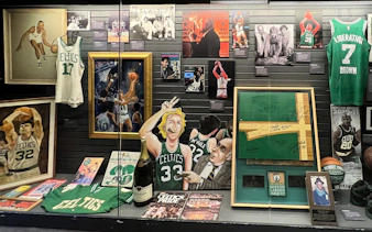 Boston Sports Museum exhibit featuring Celtics memorabilia, including jerseys, signed items, and historic photos.