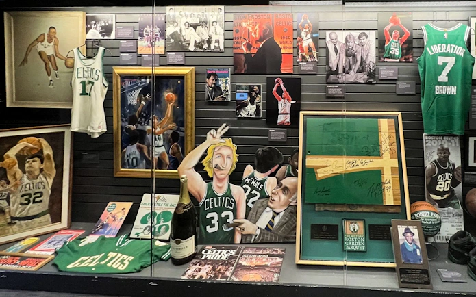 Boston Sports Museum exhibit featuring Celtics memorabilia, including jerseys, signed items, and historic photos.