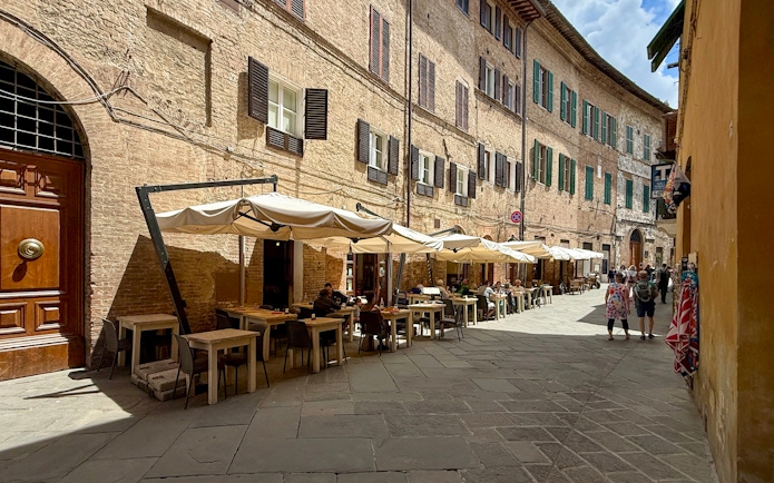 Outdoor seating at a cafe in Siena, Italy, ideal for pasta cooking classes.