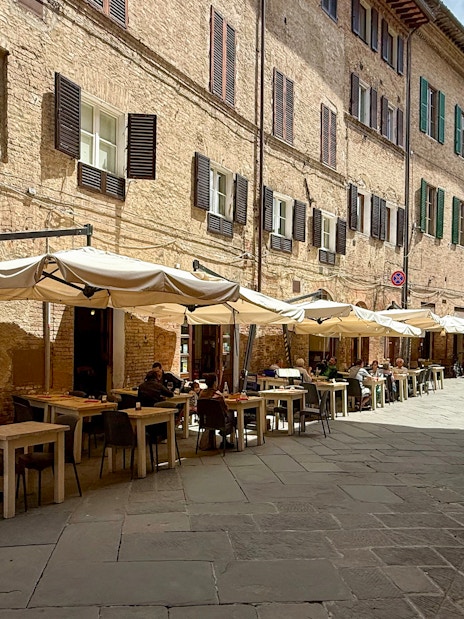 Outdoor seating at a cafe in Siena, Italy, ideal for pasta cooking classes.
