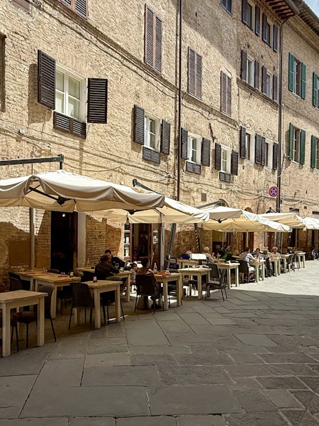 Outdoor seating at a cafe in Siena, Italy, ideal for pasta cooking classes.