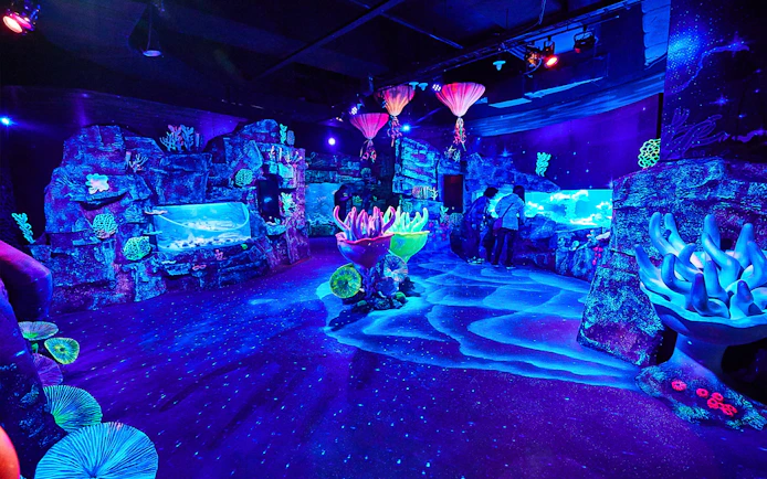 SEA LIFE Busan Aquarium glowing coral displays and visitors exploring exhibits.
