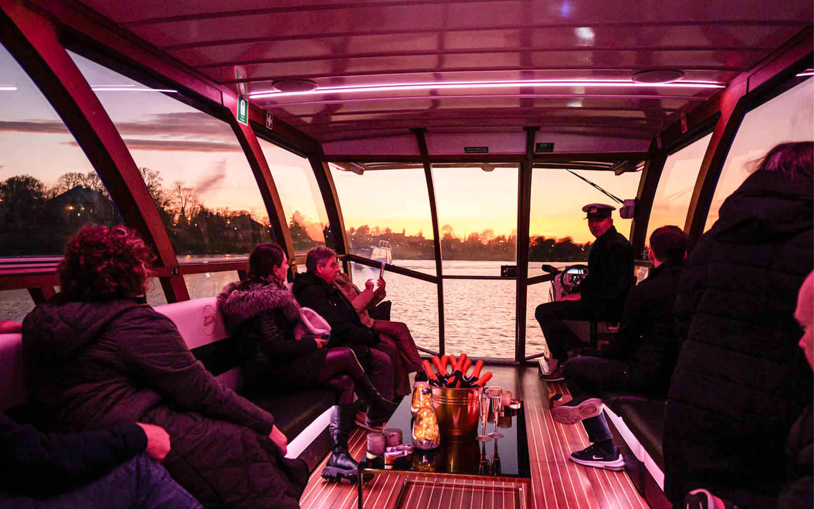 Cruise passengers enjoy sunset views on a Vistula River catamaran in Krakow.