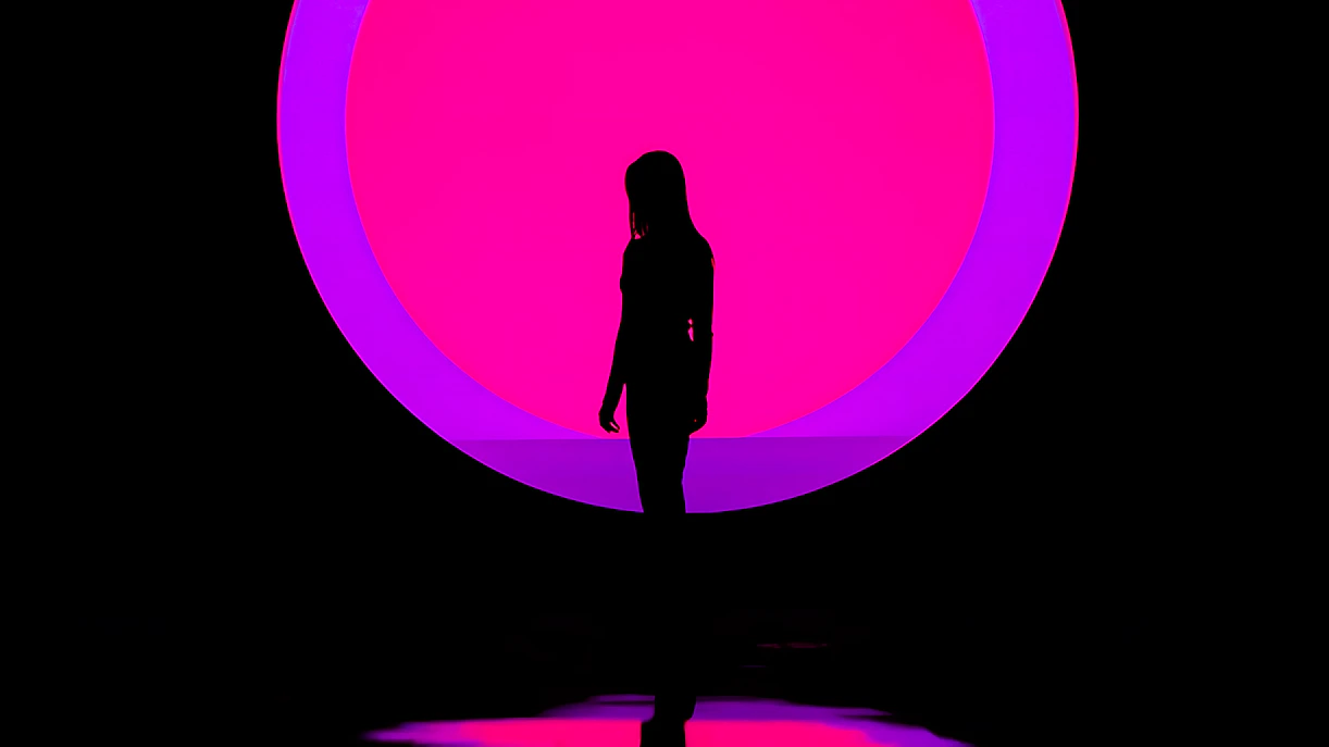 Silhouette of a person in front of a vibrant pink and purple circle at ARTE Museum.