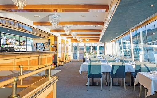 Interior of a dining area on a Danube cruise ship in Budapest, set for an evening dinner.