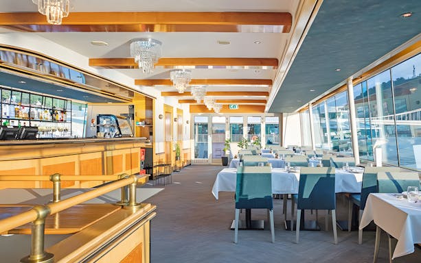 Interior of a dining area on a Danube cruise ship in Budapest, set for an evening dinner.