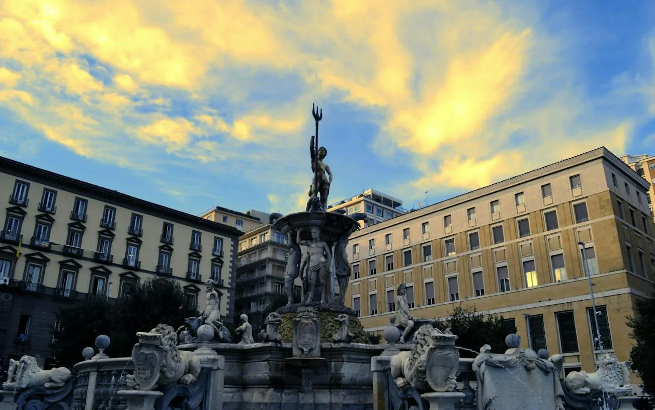Fountain of Neptune in Naples city square during sunset.