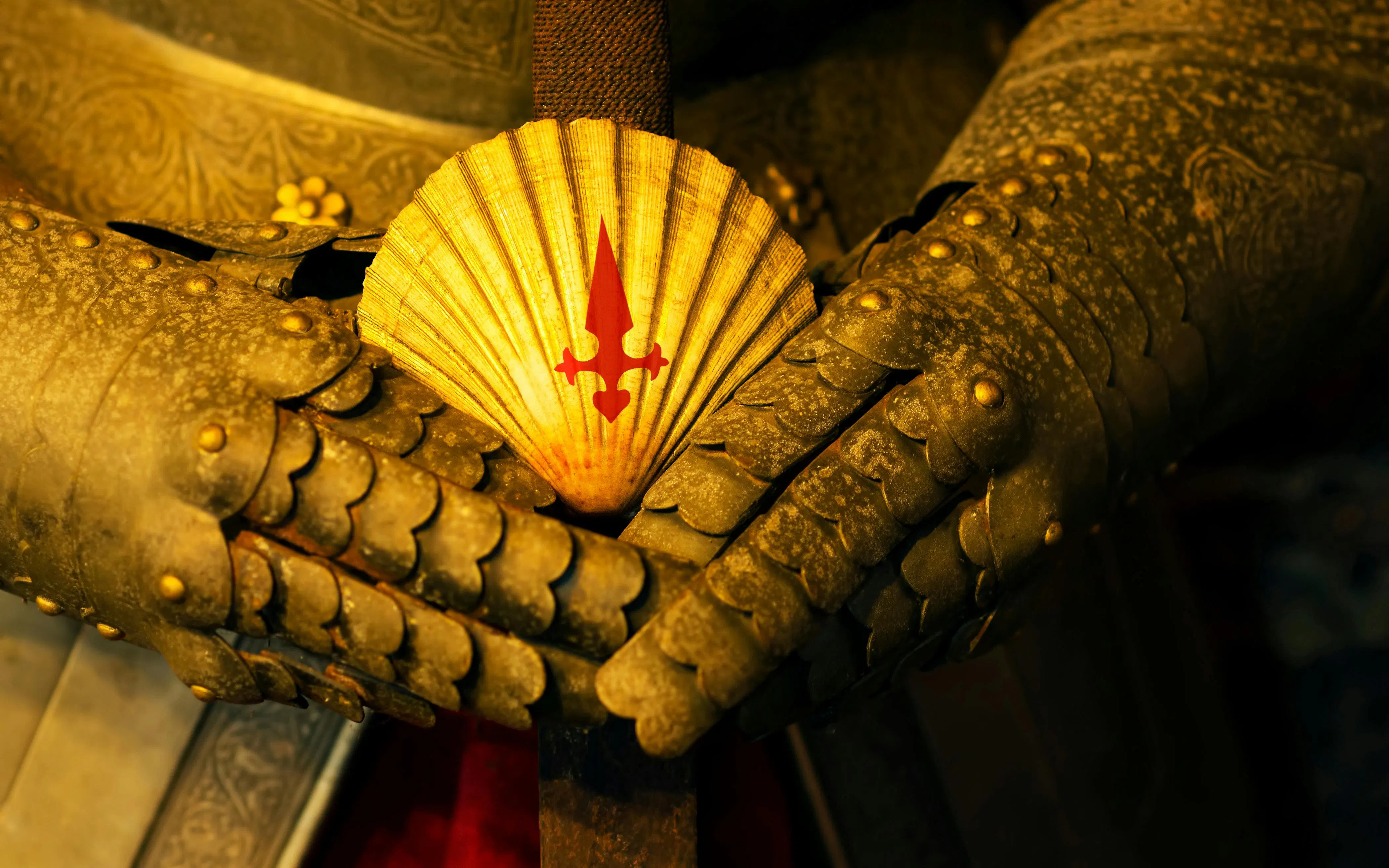 Scallop shell with red cross on sword hilt, medieval armor, Camino de Santiago, Spain.