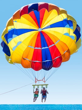 Parasailing over the ocean in Langkawi with colorful parachute.