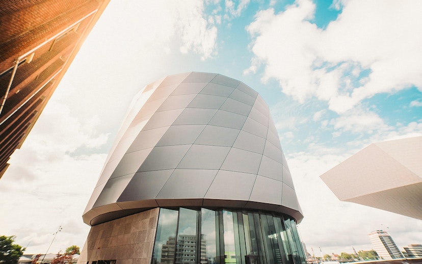 Modern architecture of This is Holland building in Amsterdam under a blue sky.