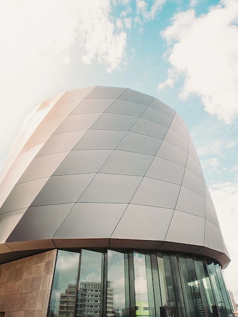 Modern architecture of This is Holland building in Amsterdam under a blue sky.