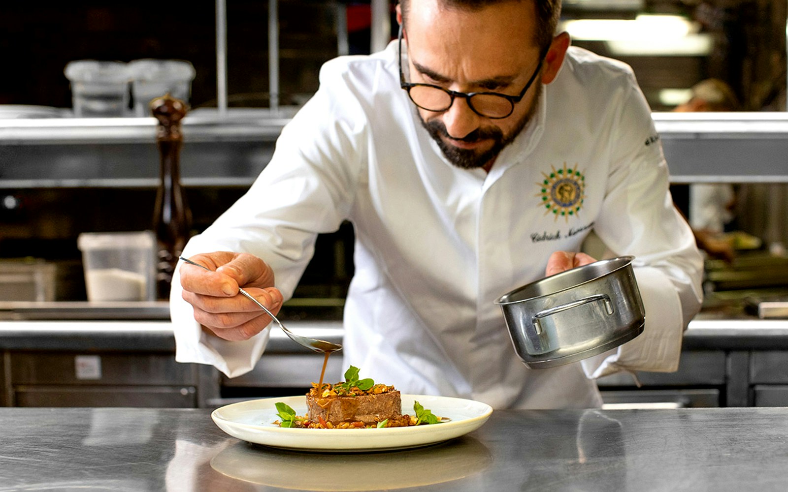 Chef preparing gourmet dish for Paris New Year’s Eve 2025 cruise by Bateaux Parisiens.