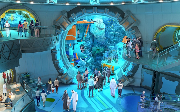 Visitors exploring an underwater-themed attraction with large viewing windows.