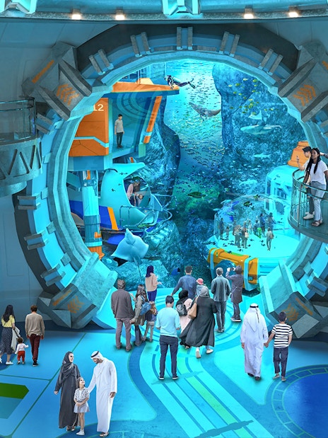 Visitors exploring an underwater-themed attraction with large viewing windows.