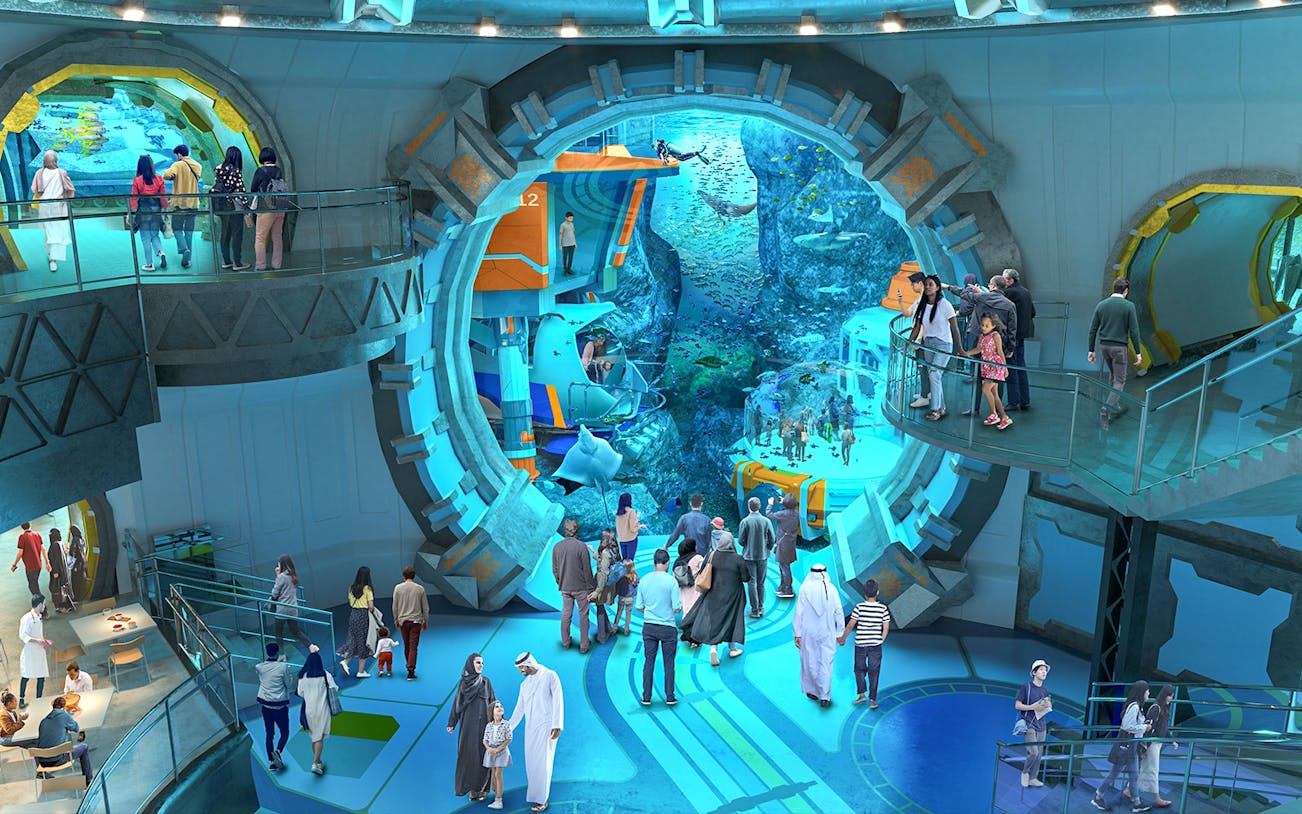 Visitors exploring an underwater-themed attraction with large viewing windows.