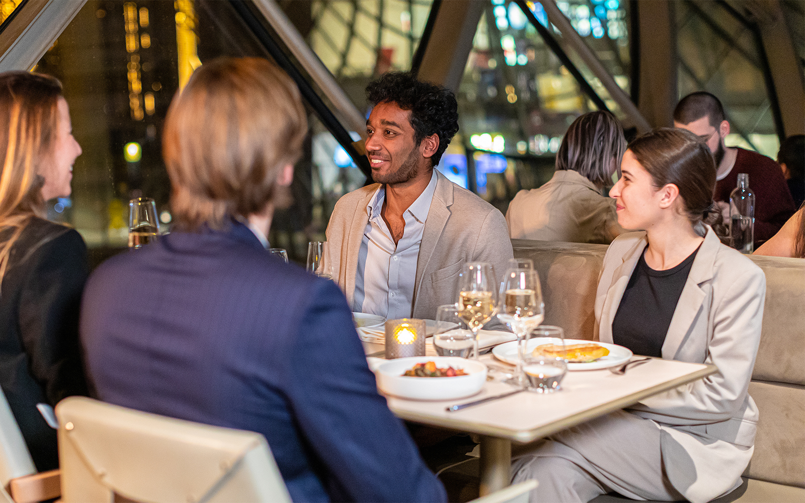 Dinner conversation at Madame Brasserie, Paris, with people enjoying a meal.