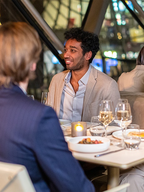 Dinner conversation at Madame Brasserie, Paris, with people enjoying a meal.