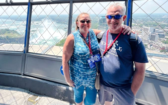 Visitors enjoying the view of Niagara Falls from a tower observation deck.
