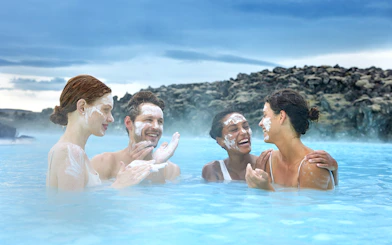 Tourists applying silica mud at Blue Lagoon Geothermal Pool, Iceland.