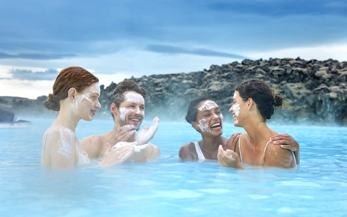 Tourists applying silica mud at Blue Lagoon Geothermal Pool, Iceland.