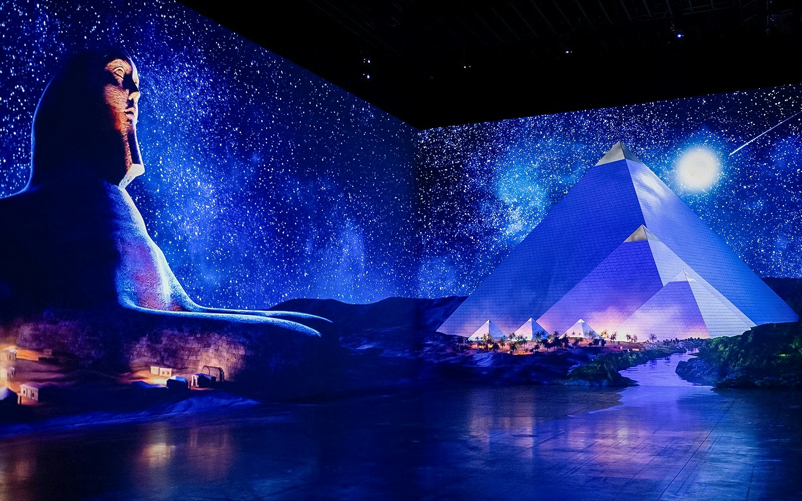 Digital projection of the Sphinx and pyramids under a starry night sky at the Grand Egyptian Museum, Cairo.