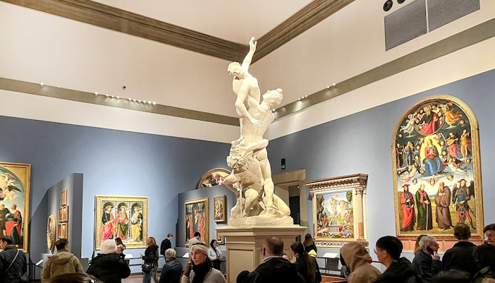 A grande entrada da Galeria Accademia em Veneza com visitantes reunidos, mostrando a arquitetura clássica e a sinalização proeminente da galeria