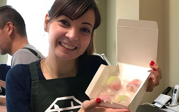 Participant holding a box of handmade wagashi during a Tokyo wagashi-making class.