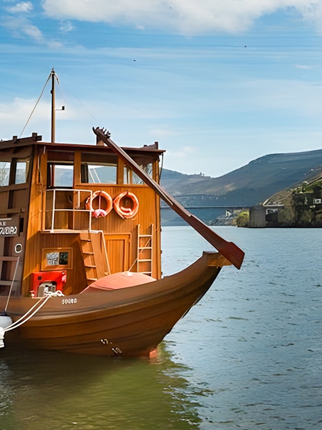 Boat on Douro River with vineyard hills in Douro Valley, Portugal.