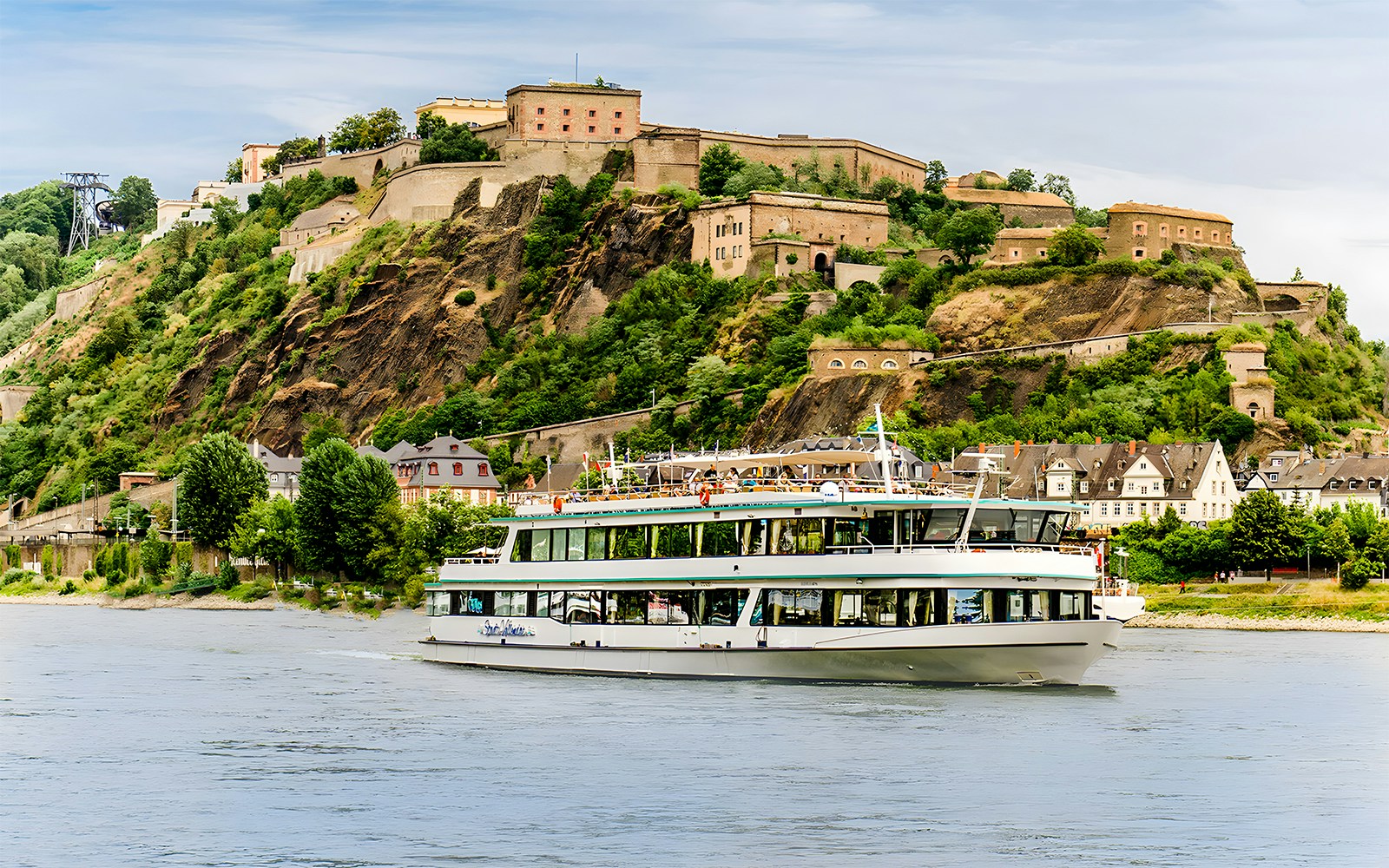Passengers enjoying a Koblenz Sightseeing Cruise on the Moselle River with a scenic view of the cityscape