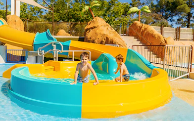 Kids playing on Mini Turbolance slide at Aquopolis Villanueva de la Cañada.