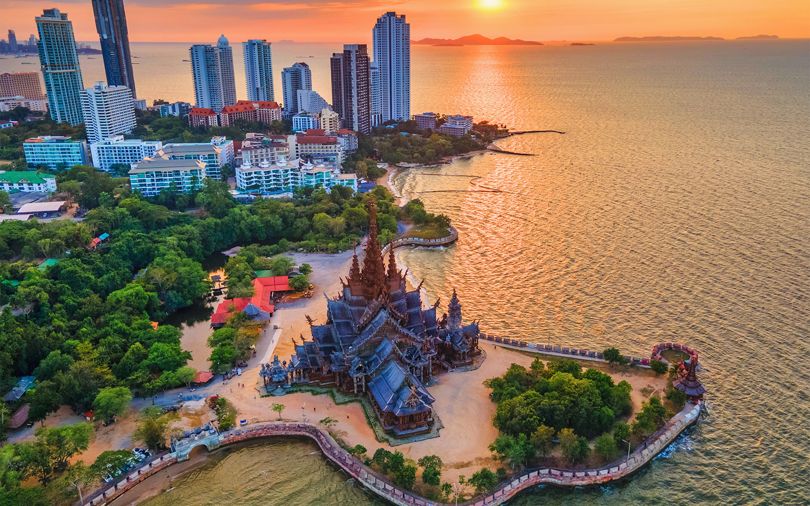 Aerial view of the Sanctuary of Truth in Pattaya, Thailand, with surrounding coastline and cityscape.