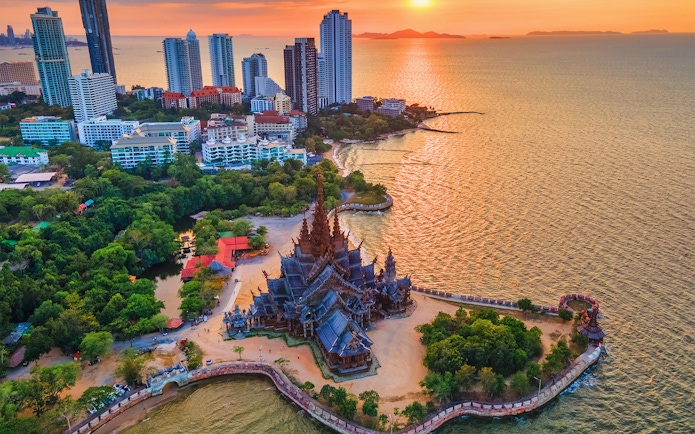 Aerial view of the Sanctuary of Truth in Pattaya, Thailand, with surrounding coastline and cityscape.