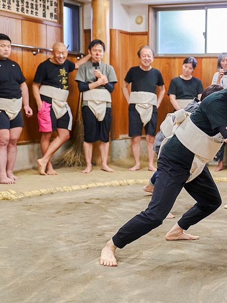 Sumo wrestlers practicing in a traditional dojo in Koto City.