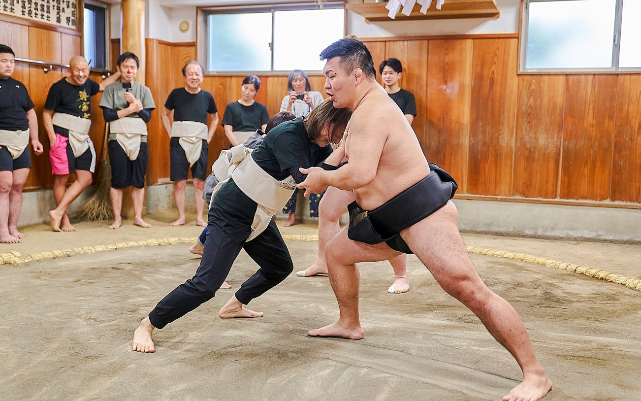 Sumo wrestlers practicing in a traditional dojo in Koto City.