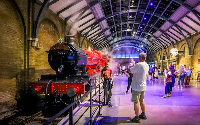 Hogwarts Express at Warner Bros. Studio Tour London with visitors taking photos.