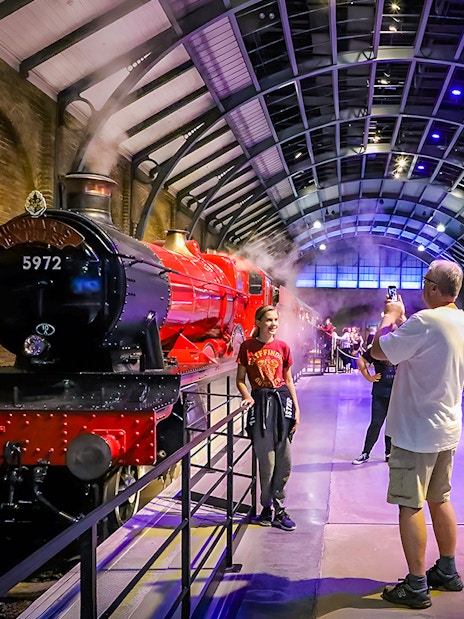 Hogwarts Express at Warner Bros. Studio Tour London with visitors taking photos.