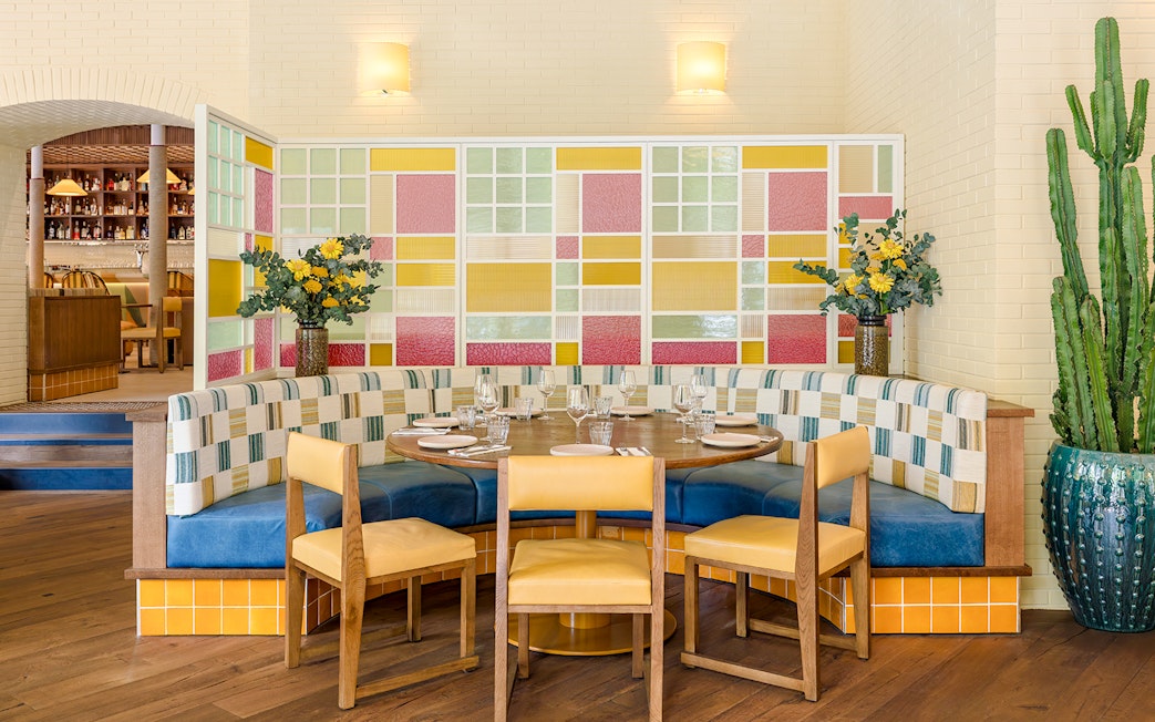 Interior of Brasserie Auteuil with colorful seating and decorative plants.