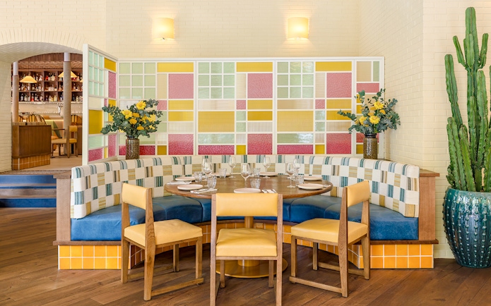 Interior of Brasserie Auteuil with colorful seating and decorative plants.