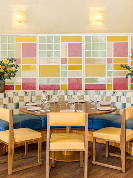 Interior of Brasserie Auteuil with colorful seating and decorative plants.