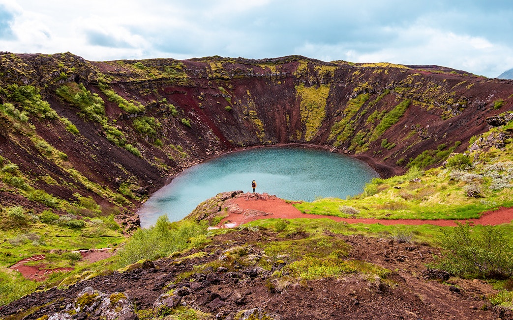 Kerid Crater with turquoise water and red volcanic rock in Iceland.