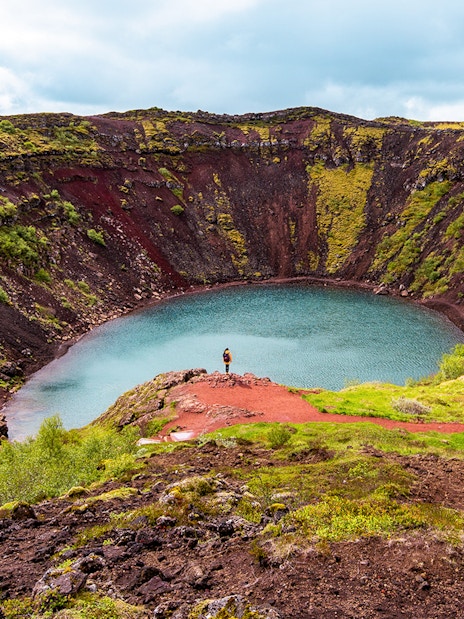 Kerid Crater with turquoise water and red volcanic rock in Iceland.