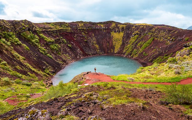 Kerid Crater with turquoise water and red volcanic rock in Iceland.