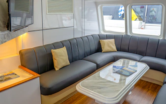 Ferry interior with cushioned seating and table, Singapore to Batam route.