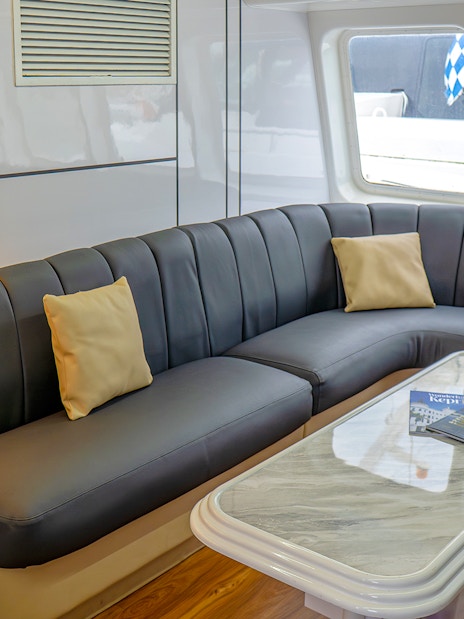 Ferry interior with cushioned seating and table, Singapore to Batam route.